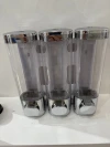 The wall-mounted double-box soap dispenser for hotels and guesthouses can be used to dispense shampoo and body wash into bottles by pressing Specification image